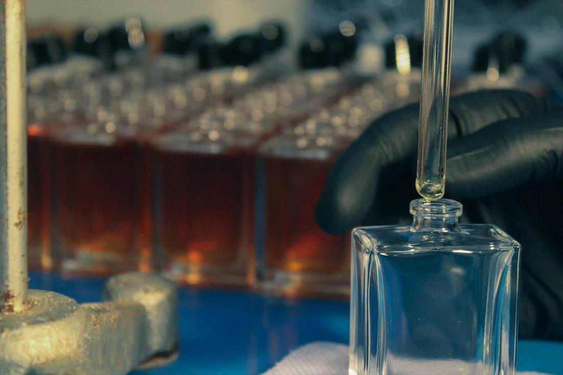 Perfume being filled into glass bottles