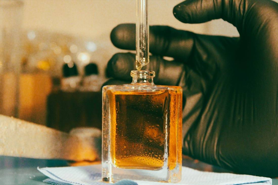 Gloved hand adding fragrance with a dropper