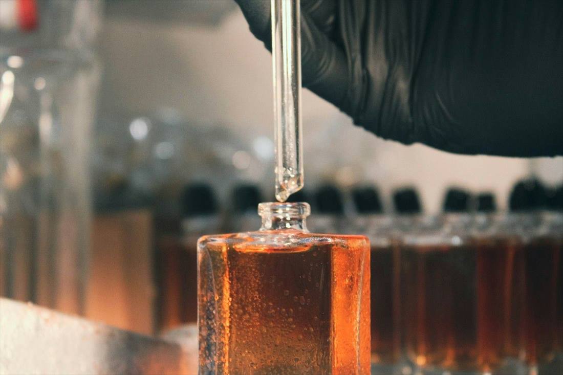 Perfumer measuring fragrance oil with a pipette